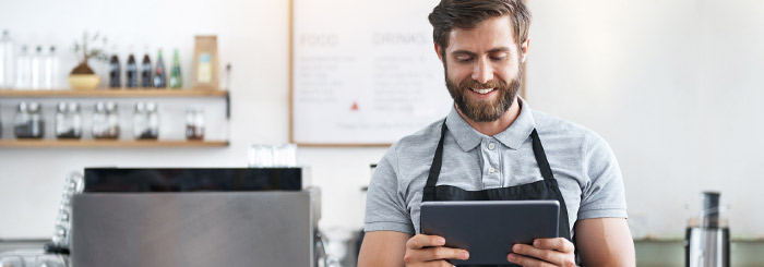 Small business owner on his tablet for online banking and account balance 
