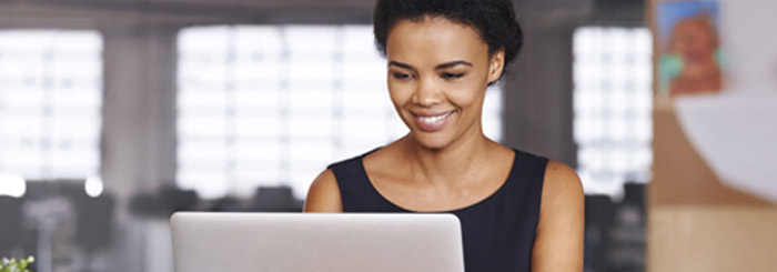 Smiling female on her laptop for electronic deposit secure safe