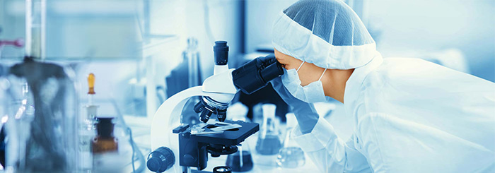 Scientist looking through microscope for biotech and life science research