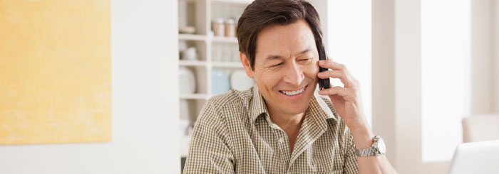 Smiling optimistic man on the phone with a loan servicing specialist