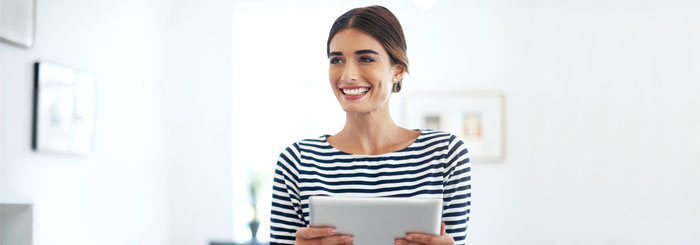 Smiling business woman holding a tablet in office